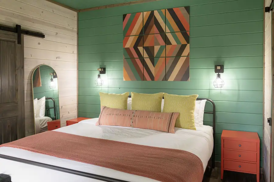 King suite with green shiplap and a geometric southwestern artwork