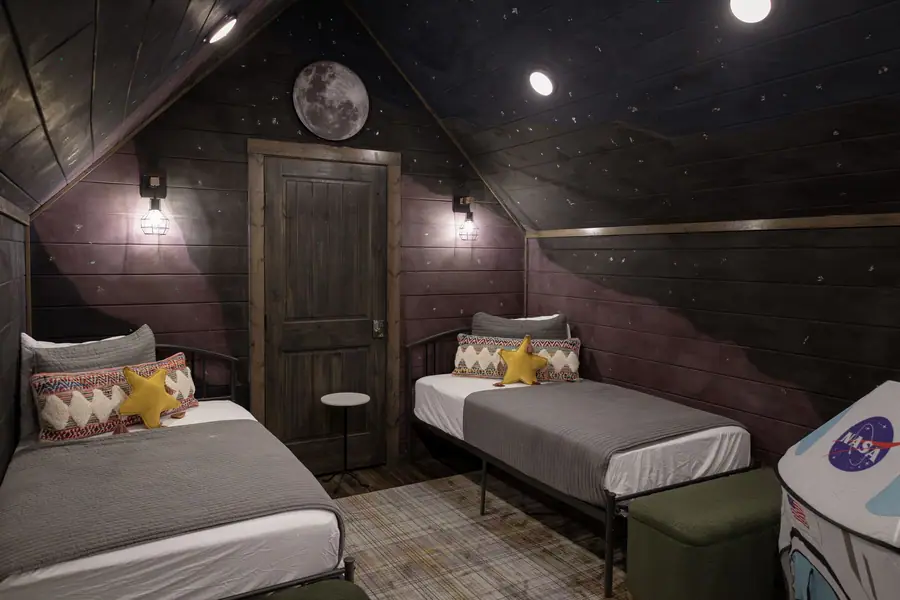 Loft with two twin beds under a galaxy-painted ceiling and a moon light