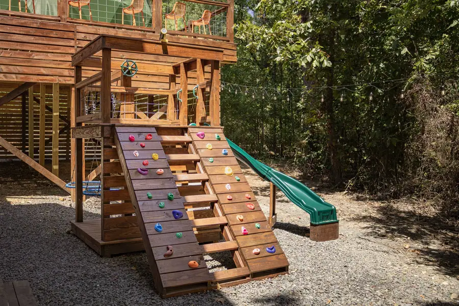 Playset with climbing wall and slide
